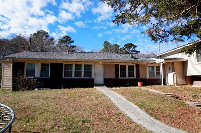 a front view of a house with a yard and outdoor seating