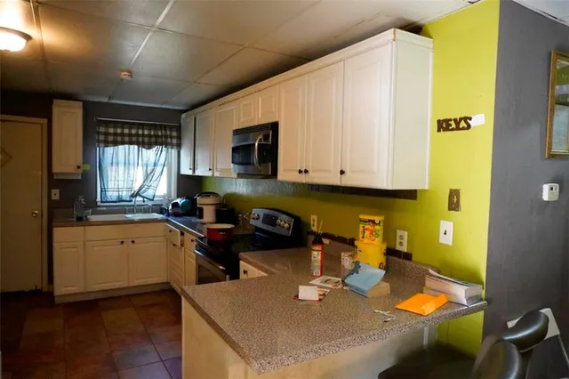 a kitchen with stainless steel appliances granite countertop a sink a stove and cabinets