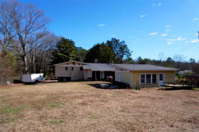 a view of a house with a yard and sitting area