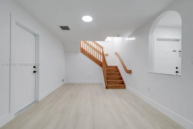 wooden floor in an empty room with a staircase