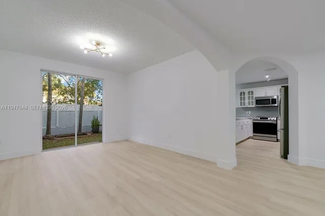 wooden floor in an empty room with a kitchen