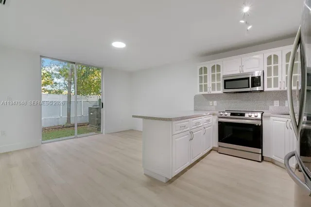 a kitchen with stainless steel appliances granite countertop a stove a sink and a microwave