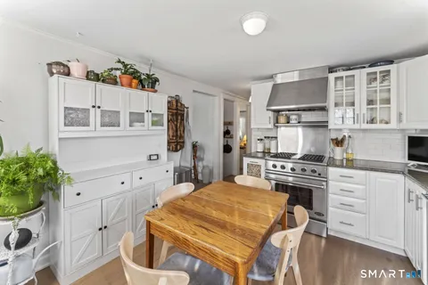 a kitchen with stainless steel appliances a stove a refrigerator and a white cabinets