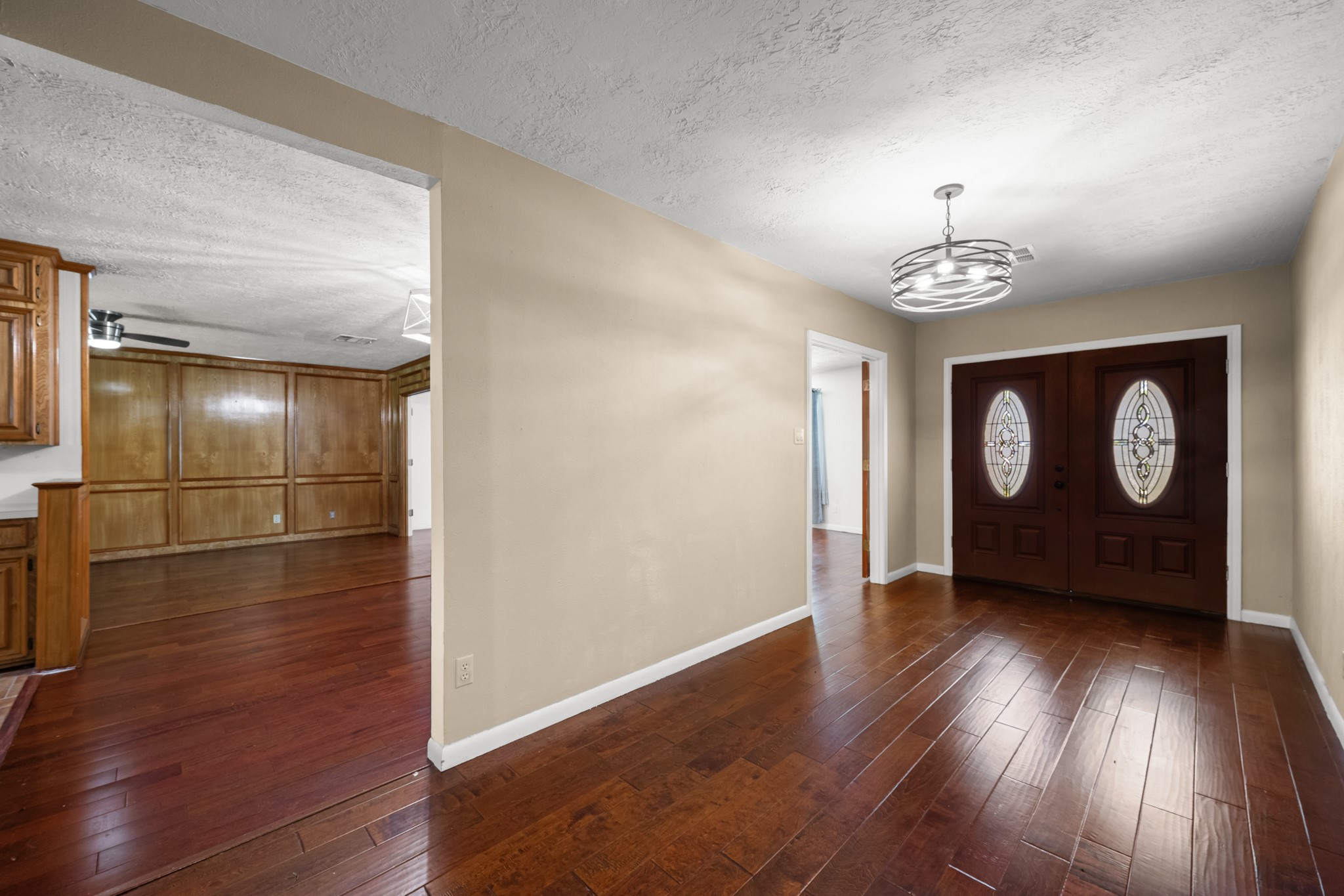 616 Cannan Drive Angleton, TX 77515 - Photo 3 of 49 The welcoming foyer features rich wood-look flooring, updated lighting, and elegant double front doors with decorative glass inserts. This spacious entry creates a warm introduction to the home and provides a seamless flow into the adjoining living areas.