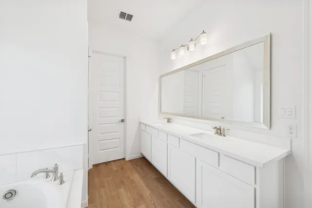 a bathroom with a double vanity sink mirror and