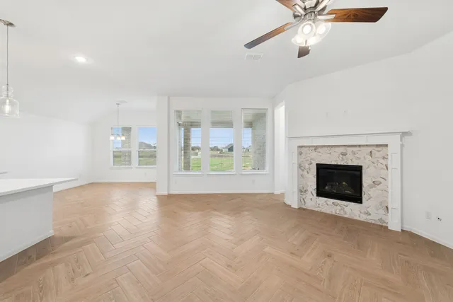 an empty room with windows and fireplace