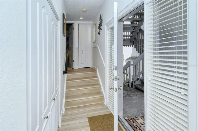 a view of a hallway with wooden floor and staircase
