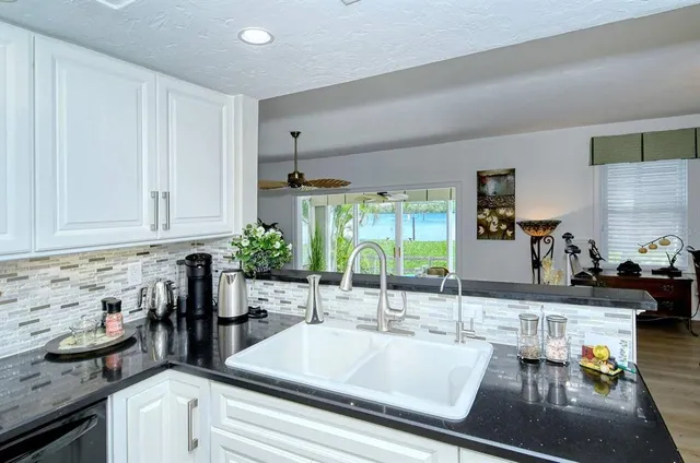 a kitchen with granite countertop a sink and a stove top oven