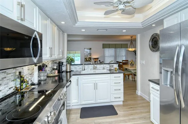 a kitchen with stainless steel appliances granite countertop a sink a stove and a refrigerator