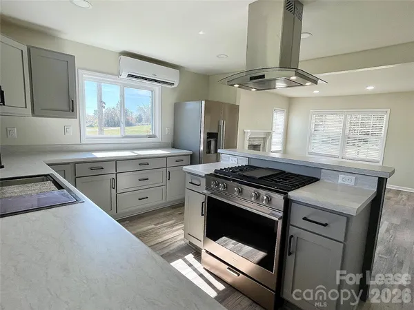 a kitchen with stainless steel appliances a stove a sink and white cabinets