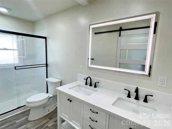 a bathroom with a sink a toilet and shower