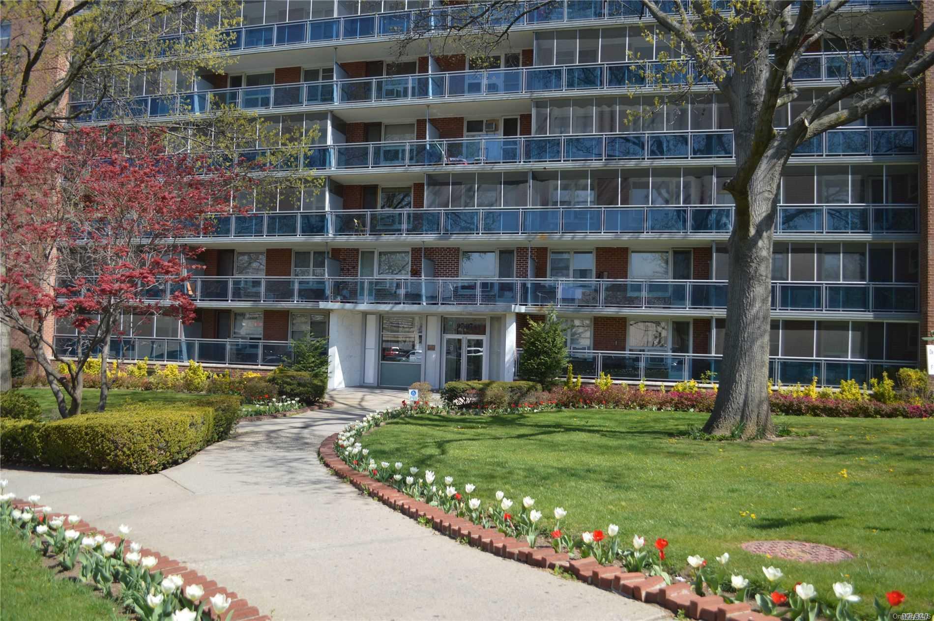 97-07 63rd Road, Unit 8A Queens, NY 11374 - Photo 1 of 1 a front view of building with yard