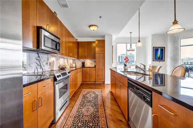 a kitchen with stainless steel appliances granite countertop a refrigerator sink and stove