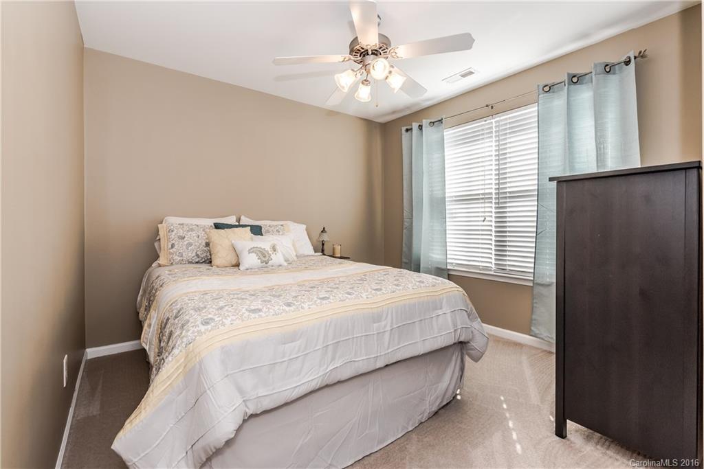 816 Gentlewinds Court, Unit 816 Fort Mill, SC 29708 - Photo 19 of 24 a bedroom with a bed and a chandelier