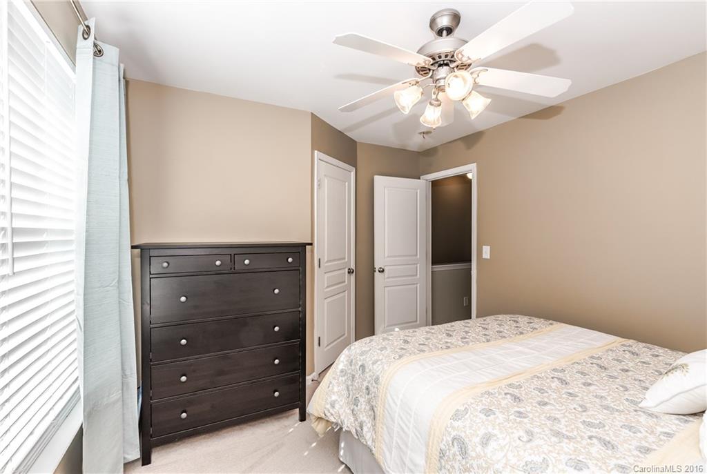 816 Gentlewinds Court, Unit 816 Fort Mill, SC 29708 - Photo 20 of 24 a bedroom with a bed a chandelier and a dresser