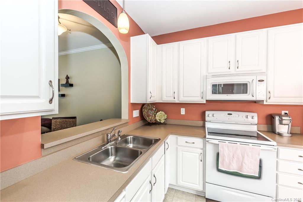 816 Gentlewinds Court, Unit 816 Fort Mill, SC 29708 - Photo 4 of 24 a kitchen with stainless steel appliances granite countertop a sink and a microwave oven with white cabinets