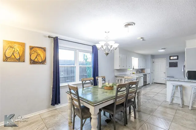 a view of a dining room with furniture and a chandelier