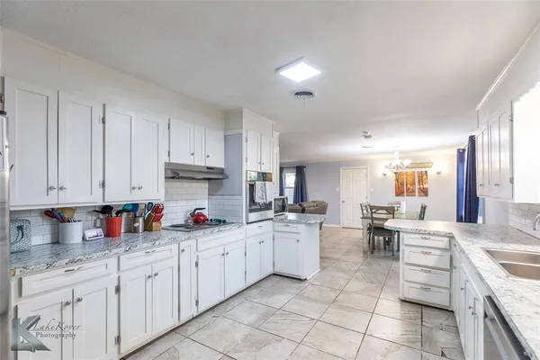 a kitchen with stainless steel appliances granite countertop a sink dishwasher stove and cabinets
