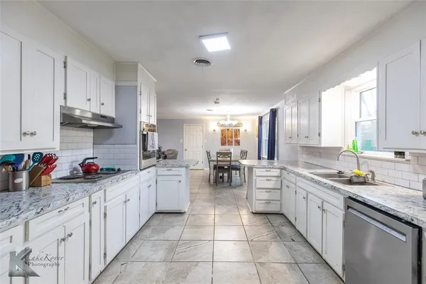 a kitchen with lots of counter top space appliances and cabinets