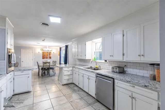 a kitchen with stainless steel appliances granite countertop a sink a stove counter space and cabinets