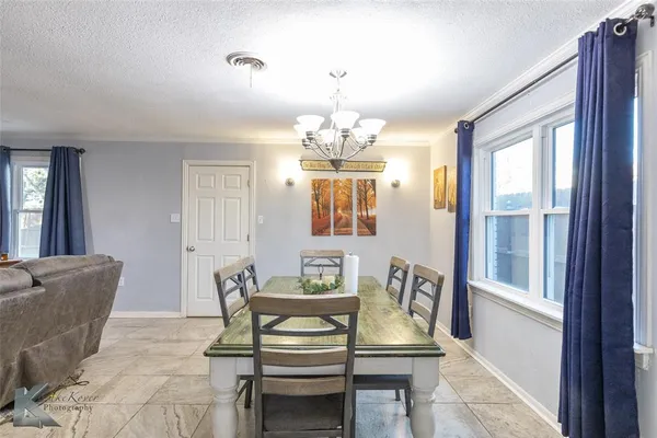 a dining room with wooden floor and windows
