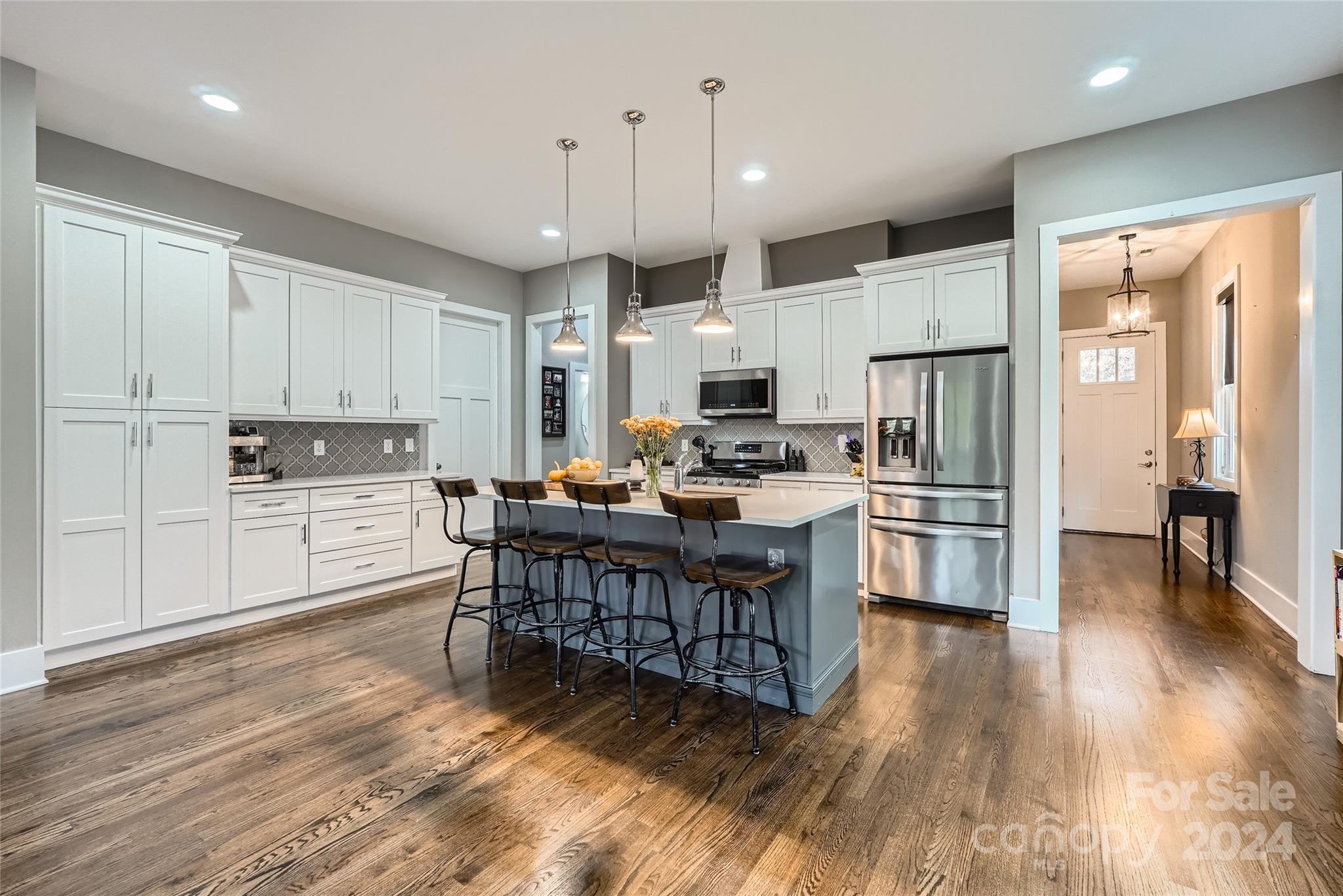 5220 Valley Stream Road Charlotte, NC 28209 - Photo 8 of 24 a kitchen with stainless steel appliances kitchen island granite countertop a refrigerator a stove top oven a sink dishwasher and white cabinets with wooden floor