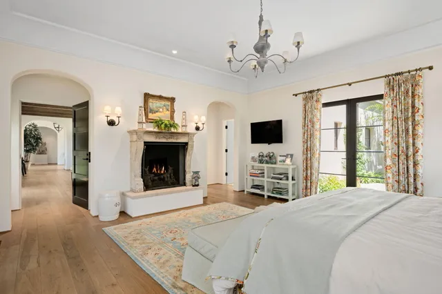 a large bedroom with a large bed and a flat tv screen