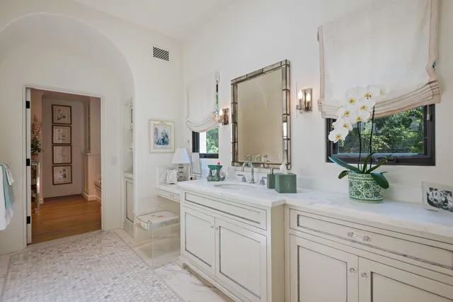 a bathroom with a double vanity sink a mirror and a window