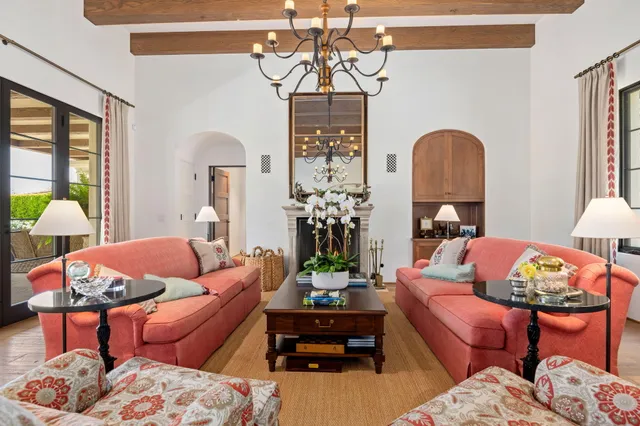 a living room with furniture a chandelier and a window