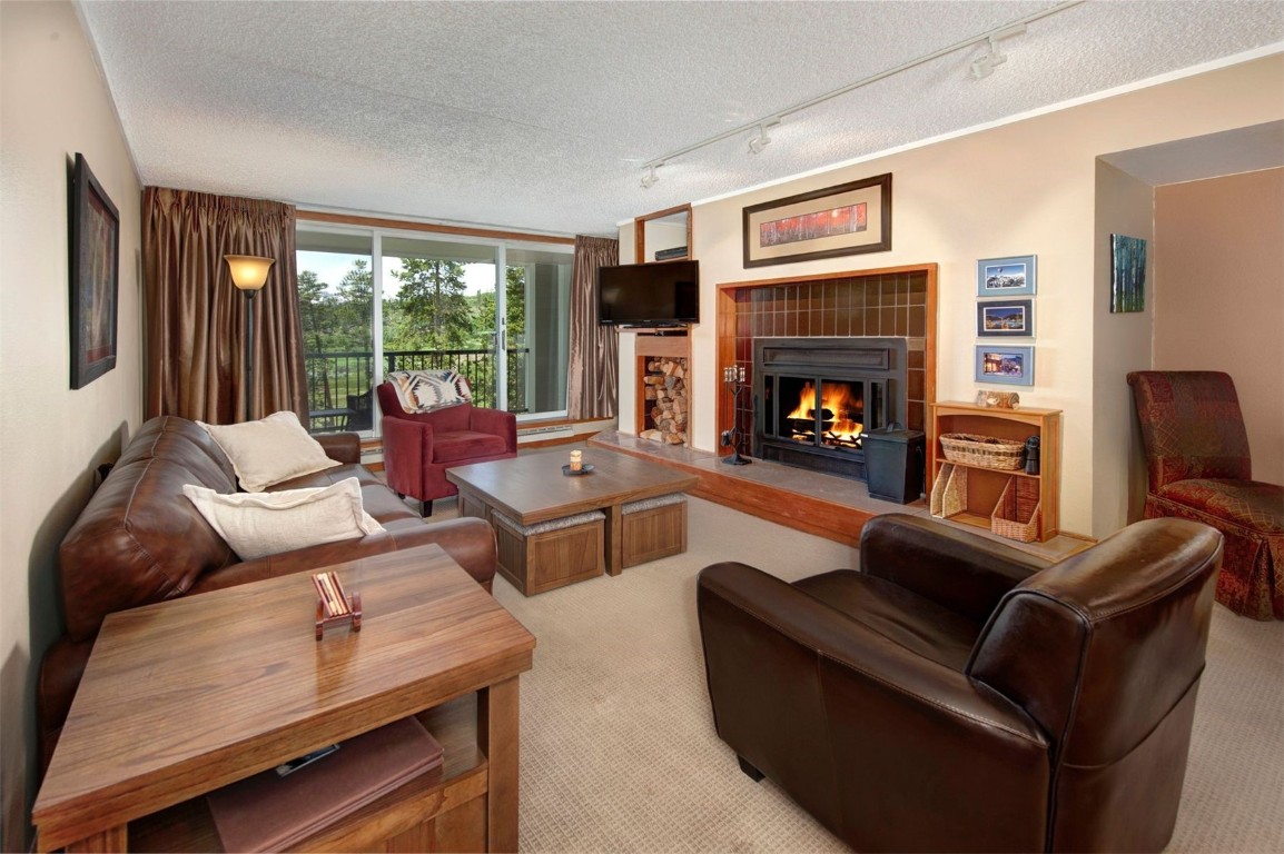 a living room with furniture fireplace and a large window