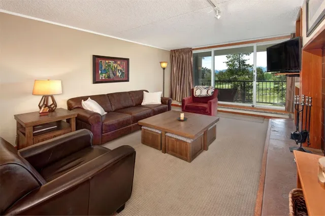a living room with furniture and a floor to ceiling window