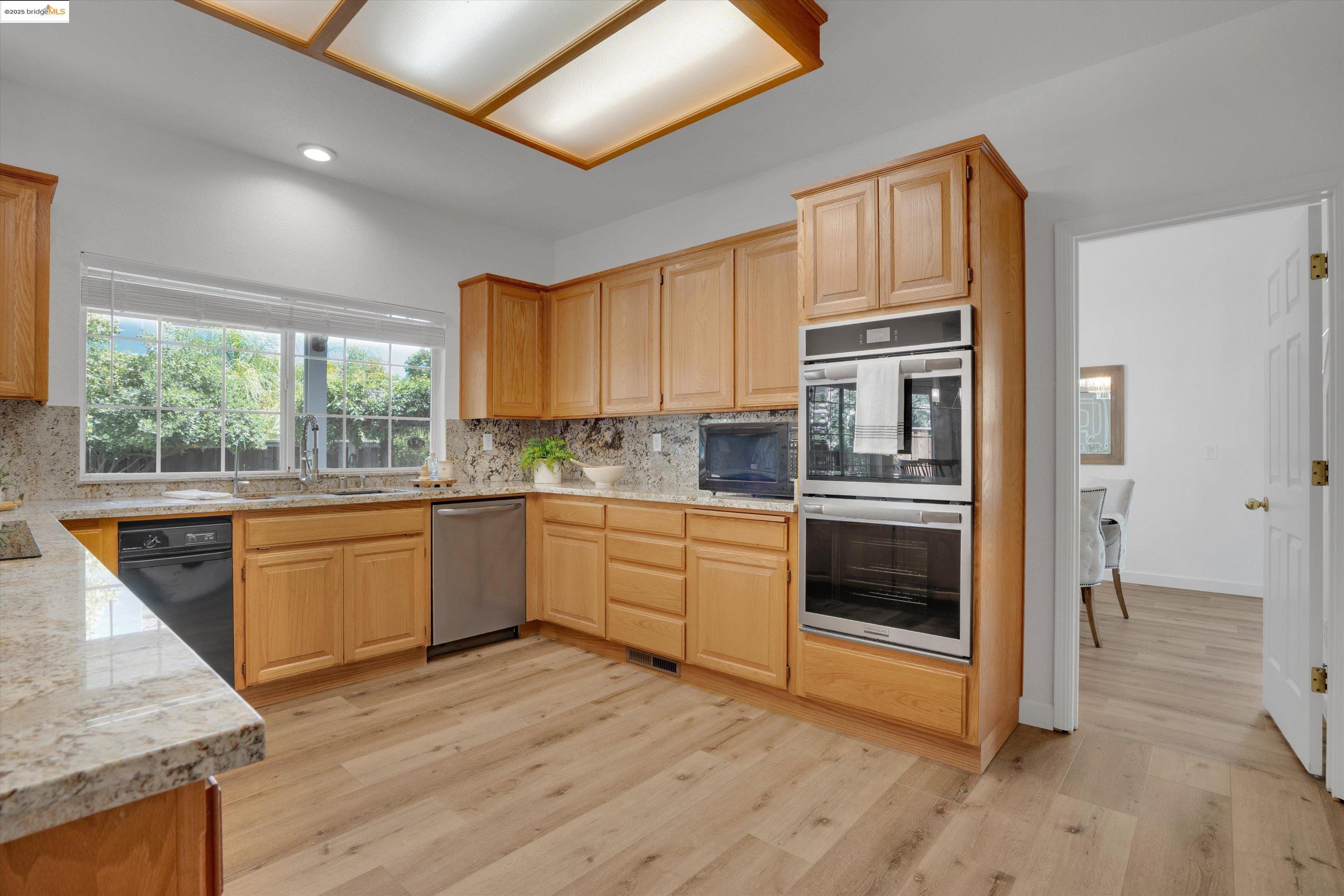 805 Devonshire Loop Brentwood, CA 94513 - Photo 11 of 51 a kitchen with stainless steel appliances granite countertop a stove a sink and a refrigerator