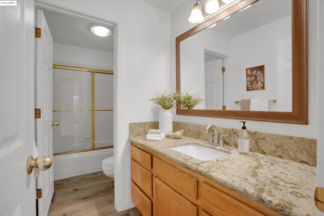 a bathroom with a granite countertop sink and a mirror