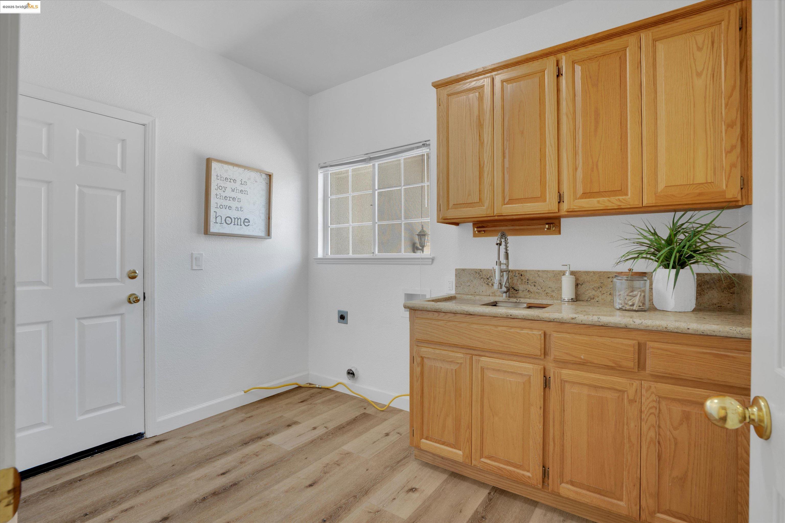 805 Devonshire Loop Brentwood, CA 94513 - Photo 18 of 51 a kitchen with white cabinets and wooden floor