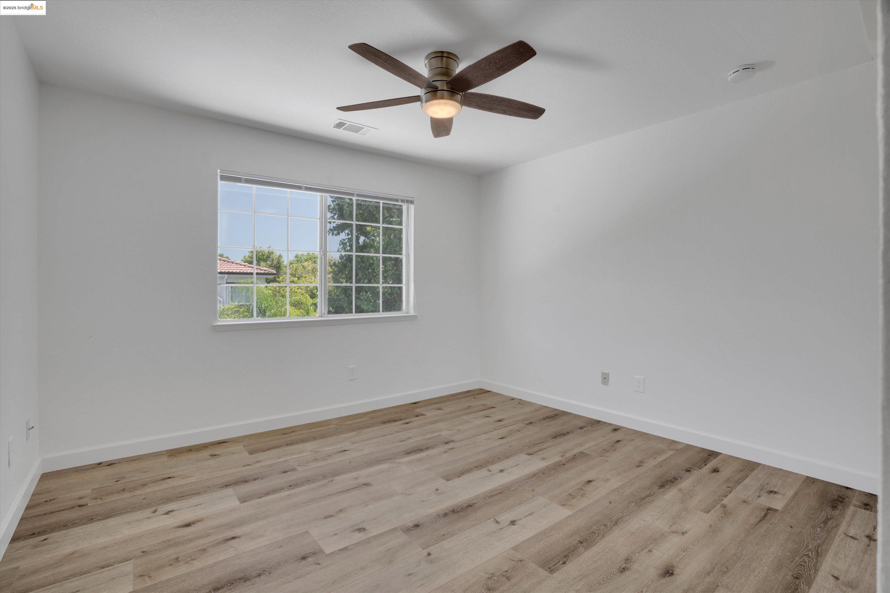 805 Devonshire Loop Brentwood, CA 94513 - Photo 22 of 51 an empty room with wooden floor and ceiling fan