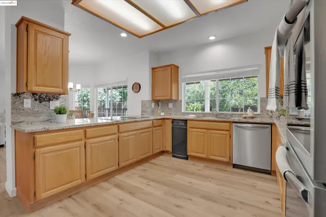 a kitchen with stainless steel appliances granite countertop a stove a sink and a microwave
