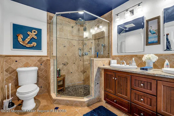 a bathroom with a granite countertop sink toilet and shower