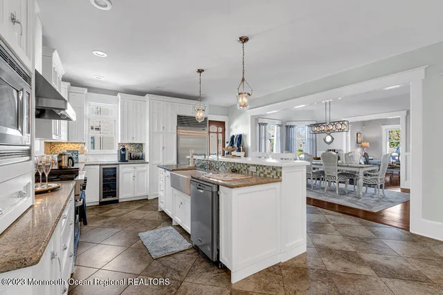 a kitchen with kitchen island granite countertop lots of counter top space and stainless steel appliances