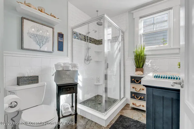 a bathroom with a granite countertop sink a toilet and shower