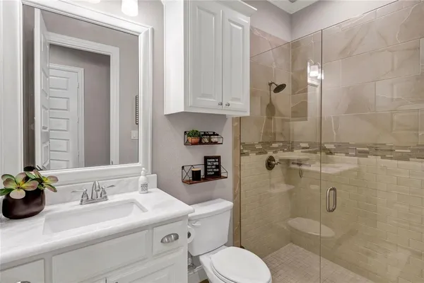 a bathroom with a sink a toilet and shower