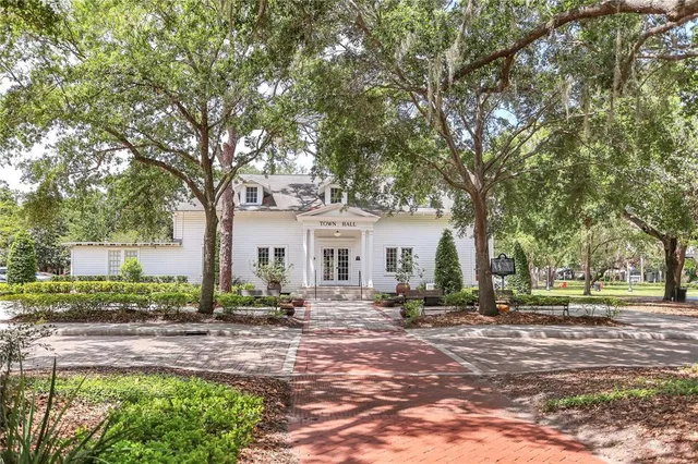 a front view of a house with a yard and trees