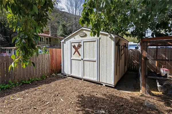a backyard of a house with plants and wooden fence