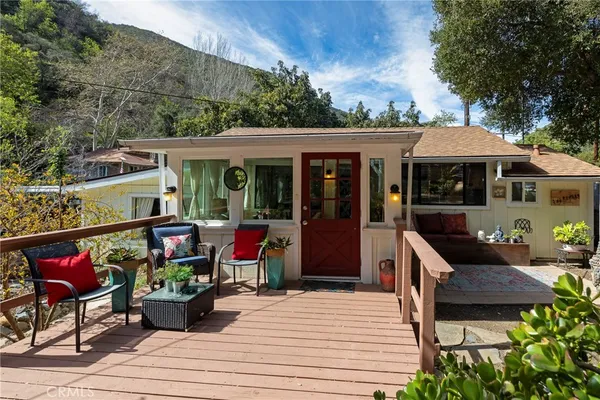 a view of a patio with table and chairs potted plants and floor to ceiling window