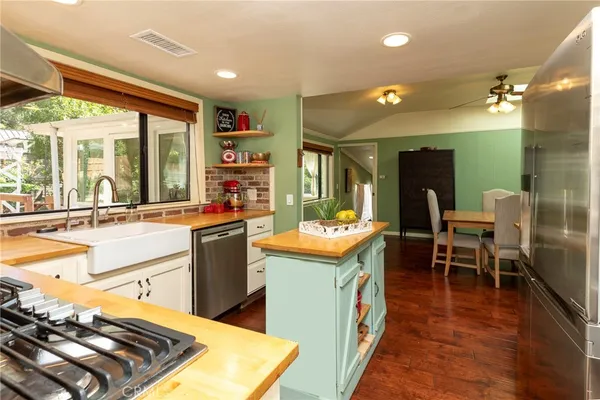 a kitchen with kitchen island granite countertop dining table chairs sink and wooden floor