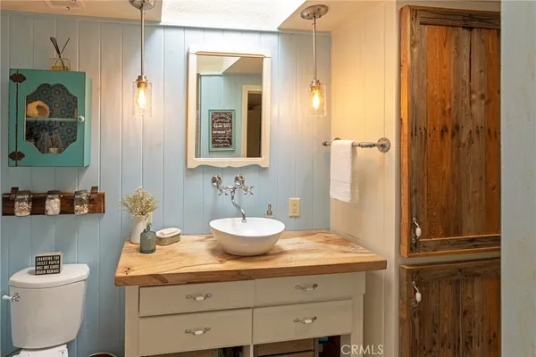 a bathroom with a granite countertop sink a toilet and a mirror