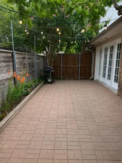 a view of a backyard with couches under an umbrella