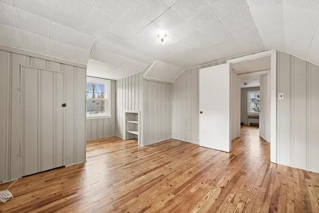a view of empty room with wooden floor