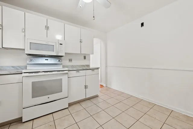 a kitchen with granite countertop white cabinets white stainless steel appliances and sink