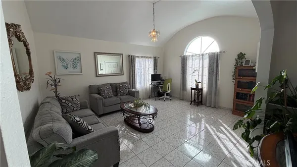 a living room with furniture chess board and a potted plant