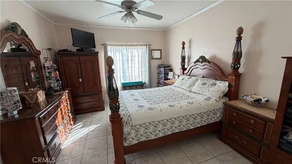 a bedroom with a bed and a flat tv screen on the dresser
